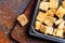 Crispy croutons with spices over wood table