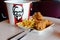 Crispy fried chicken & cup of drink served in retail background of KFC restaurant.