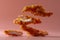 Crispy Fried Chicken Strips Levitating on Warm Pink Background, Fast Food Concept with Copy Space for Text