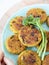 Crispy fried meatless quinoa fritters savory patties or pancakes served with fresh broccoli on a plate isolated on wooden table