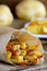 Crispy fried potatoes with spices. Delicious fried potatoes in paper and on a wooden table. Simple potato recipe. Vertical photo