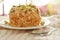 Crispy fried thin rice noodles with coconut cream topping peanut and slice lemon leaf on plate