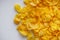 Crispy golden cornflakes on a white acrylic background