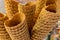 Crispy golden empty ice cream cones one over another, in a candy shop, during fast food festival