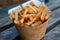 Crispy golden french fries in paper cone