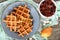 Crispy golden vanilla waffles with pear jam on a wooden background