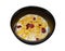 Crispy and healthy organic breakfast cereal flakes with red dried cranberry and cold soy milk in dark black handmade pottery bowl