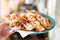 Crispy homemade pastry Brushwood lies on a plate in a woman hand