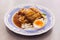 Crispy pork belly with rice pouring with gravy served with half of boiled egg