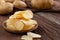 Crispy potato chips on plate with fresh potatoes on wooden table. Appetizer and Snack food