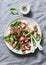 Crispy prosciutto, cherry tomatoes, spinach, parmesan salad on grey background. Delicious appetizers