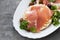 Crispy rice diet toasts with prosciutto on ceramic background