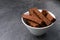 Crispy rusks in bowl on grey table, closeup