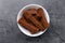 Crispy rusks in bowl on grey table, top view