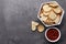 Crispy rusks and dip sauce on grey table, flat lay. Space for text