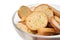 Crispy rusks with seasoning in bowl on white background, closeup