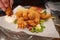 Crispy salt and pepper breaded squid with a lemon mayonnaise dip plus chilli, spring onion and corriander salad on a glass plate.