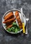 Crispy spice crust baked salmon with sweet potato and spinach - healthy balanced lunch on dark background, top view