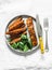 Crispy spice crust baked salmon with sweet potato and spinach - healthy balanced lunch on light background, top view