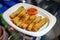 Crispy spring rolls on the paper dish in the food truck and food street event, Bangkok, Thailand, Asia