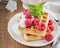 Crispy wafers with cream and fresh raspberries for