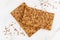 Crispy whole cereal bread with flax and sesame seeds on white marble background