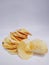 Crispy yellow round taro chips, white background