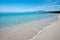 Cristal clear turquoise water, mountain and blue sky on the famous beach of Saleccia