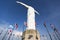 Cristo del Rey statue of Cali with world flags and blue sky, Col