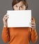 Critical middle aged woman hiding behind scary blank communication board