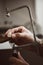 Critical moment. Close-up photo of jeweler`s hands making a silver ring with professional adjustable jeweler`s saw frame