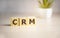 CRM banner, Customer Relationship Management, on wooden cubes over sunny background with copy space, success in business concept