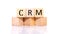 CRM, cube wooden block with alphabet combine the word abbreviation CRM on white background.