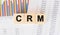 CRM word written on wood block. Faqs text on table, concept