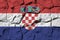 Croatia flag depicted in paint colors on old stone wall closeup. Textured banner on rock wall background