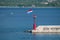 Croatian flag flying in wind on lighthouse in harbor