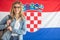 Croatian student in glasses stands in front of flag of Croatia