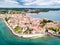 Croatian town of Porec, shore of blue azure turquoise Adriatic Sea, Istrian peninsula, Croatia. Bell tower, red tiled roofs.