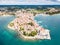 Croatian town of Porec, shore of blue azure turquoise Adriatic Sea, Istrian peninsula, Croatia. Bell tower, red tiled roofs.