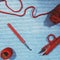 Crochet hook, scissors, yarn and woolen ball on crocheted cloth