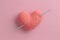 Crocheted amigurumi pink heart with crochet hook and skein of yarn on a pink background. Valentine\\\'s day banner