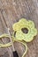 Crocheted green bloom with crochet hook and wool on wooden tablel