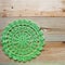 Crocheted green napkin on wooden background