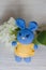 Crochetedhare of blue in yellow dress. A nice handmade toy. Photo of hydrangea