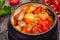 Crock pot pork roast with vegetables and cheese on wooden rustic table.