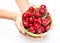 Crockery with cherries in woman hands.