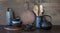 Crockery, clayware, dark utensils and other different stuff on wooden tabletop. Kitchen still life as background for