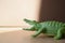 Crocodile alligator green toy with the image of an animal on a sandy background