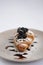 Croissant with blackberry, chocolate and powdered sugar on grey plate