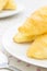 Croissant or Bread on White Dish on Placemat with Spoon Close up